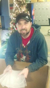 Marc Thomas, MARCA Adult Training Technician holds a few of the thousands of CD/DVD cases stored in the Recycling Building.