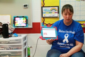 Melody Franklin, a teacher in the Step by Step autism unit at Garfield Elementary School, uses an iPad to guide instruction.