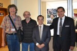 American Association of Physics Teachers members Gordon Aubrecht, Teddy Halpern, and César Mora stand with conference organizer Eduardo Montero at the conference reception area.